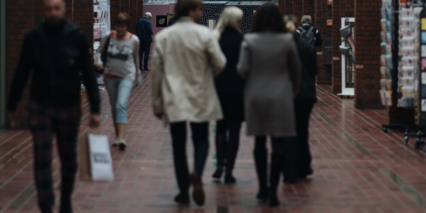 Shoppers walking with bags through the arcade of a shopping centre