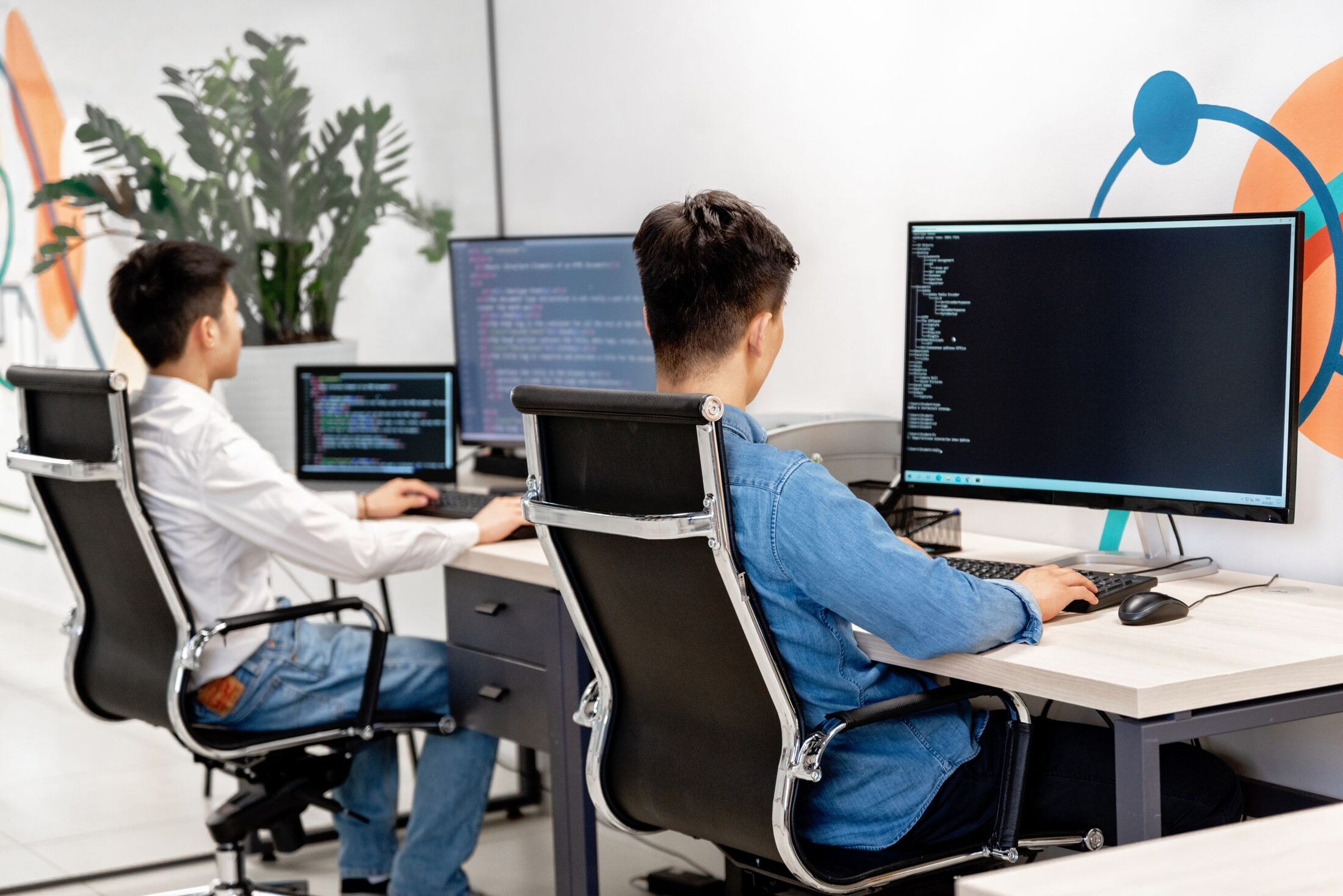 Software engineers building and reviewing code together at a shared desk