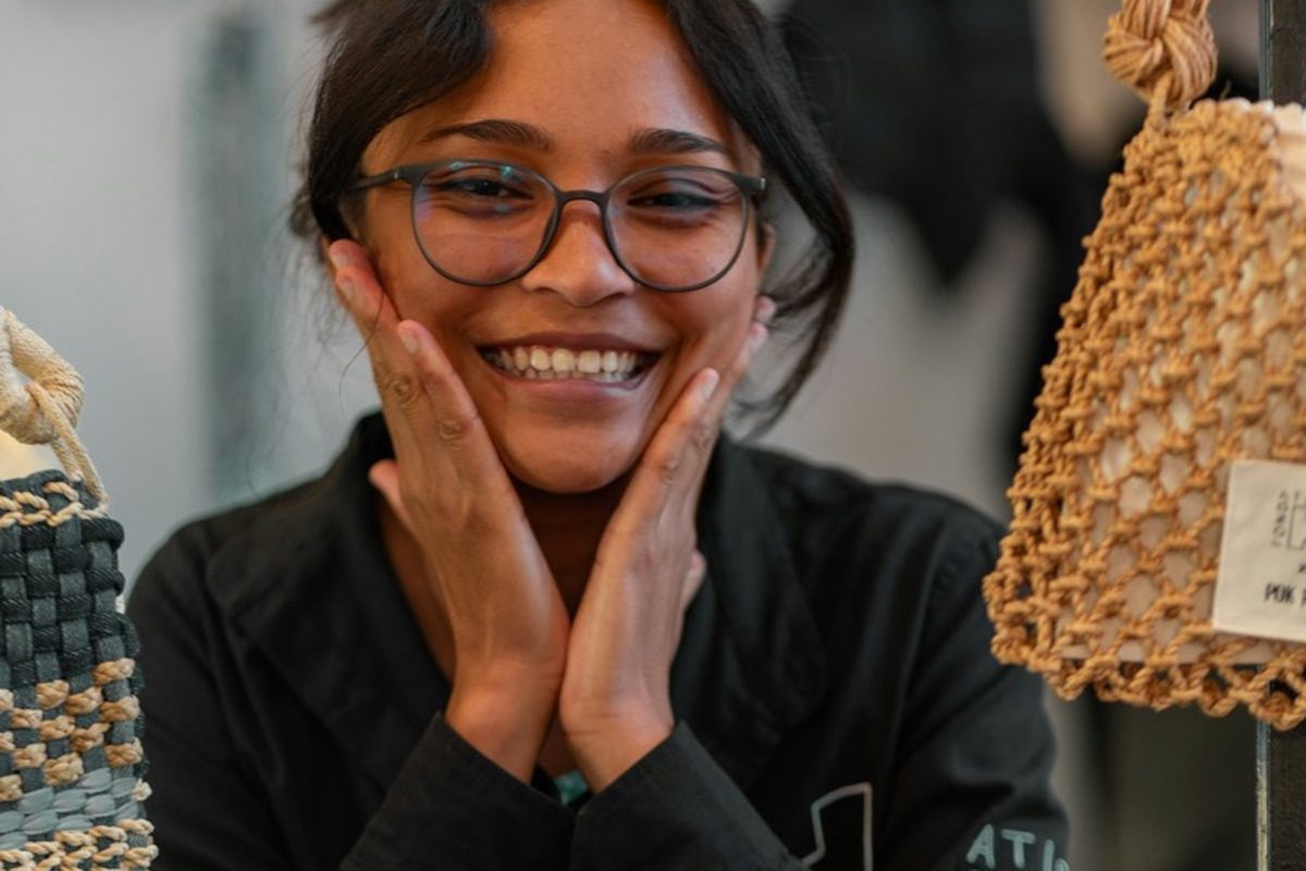 A shop owner smiling inside her store in a shopping centre